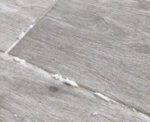 אבקה לבנה בין האריחים בריצוף כסימן לרטיבות מתחת לרצפה